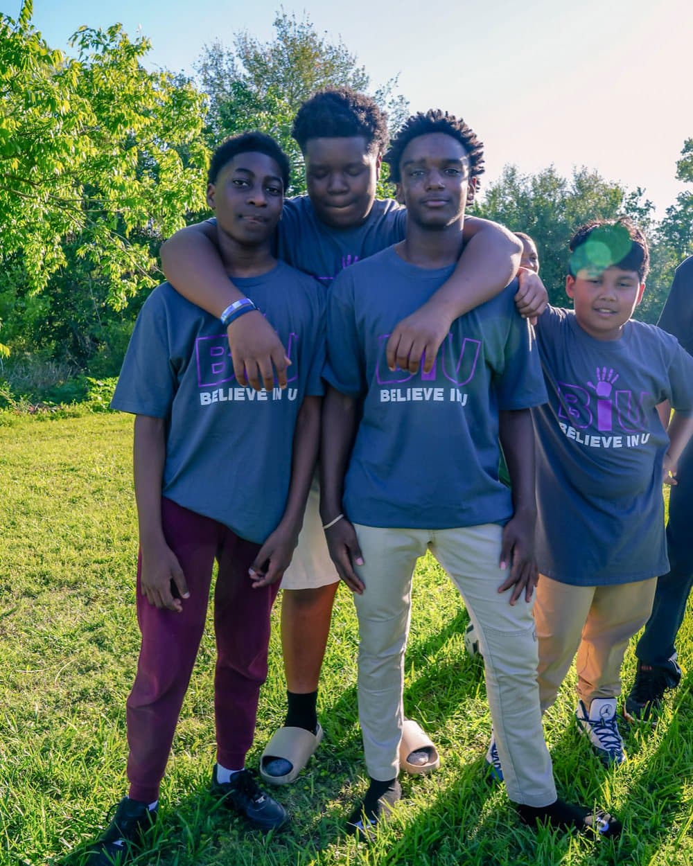 A counselor with his arm around a camper, both smiling