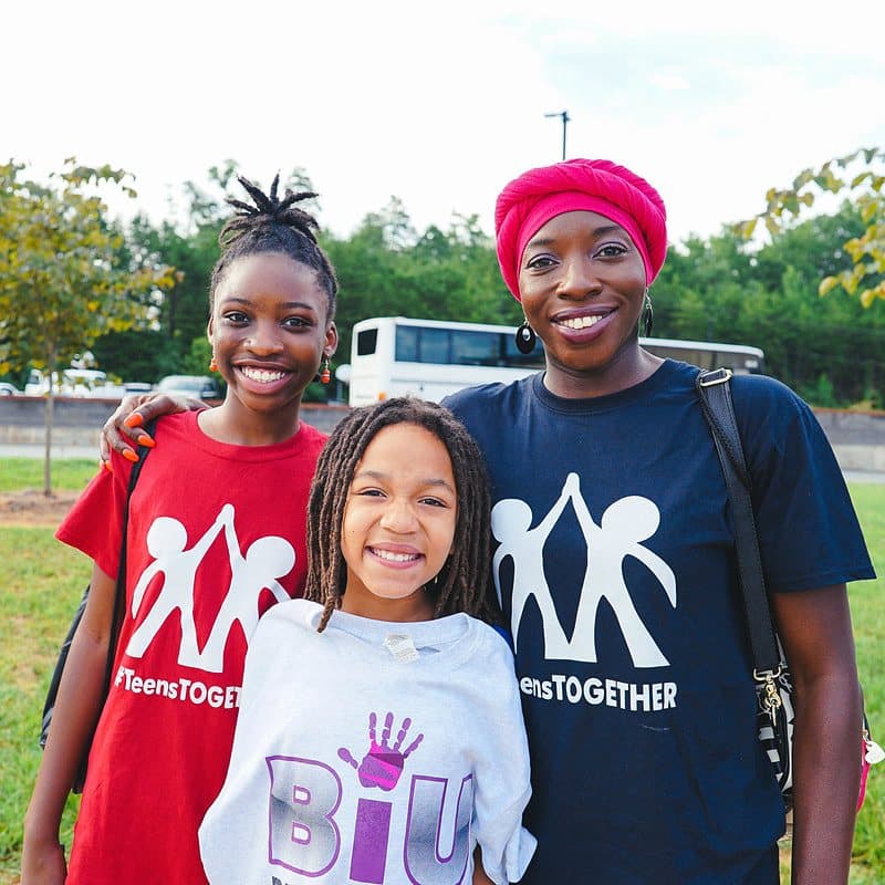 A counselor and a camper smiling together